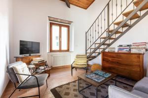 a living room with a staircase and a tv at Vuotopieno Casa Blue Maremma in Orbetello