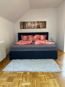 Schlafzimmer mit einem Bett mit roter Bettwäsche und einem Teppich in der Unterkunft Fewo Zentral in Willingen