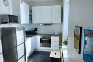 uma pequena cozinha com armários brancos e um micro-ondas em Charming city studio em Tampere