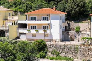 a large white house with a stone wall at Apartment in Vrbnik/Insel Krk 13610 in Vrbnik