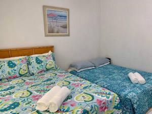 een slaapkamer met een bed met twee handdoeken erop bij SUITE 1, Blue Pavilion - Beach, Airport Taxi, Concierge, Island Retro Chic in West Bay