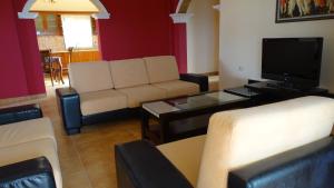 a living room with a couch and a tv at Villa Lions in Ksamil +12 photos