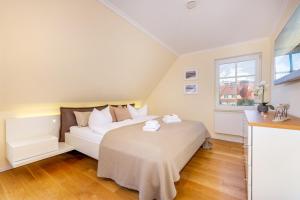 una camera da letto con un letto bianco e una finestra di Ferienhaus Zingst a Zingst Altre 12 foto