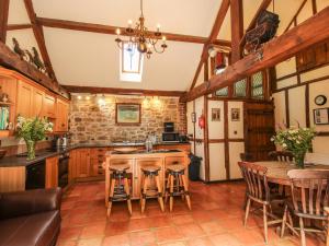 a kitchen with a sink and a table with chairs at Corn House in Plaish