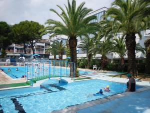 un hombre y un niño en una piscina con palmeras en Seafront, en San Benedetto del Tronto