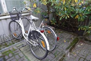 Dos bicicletas están estacionadas junto a una valla. en Charming city studio en Tampere