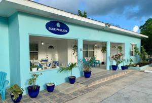 un bâtiment bleu avec des plantes en pot devant lui dans l'établissement SUITE 3, Blue Pavilion - Beach, Airport Taxi, Concierge, Island Retro Chic, à West Bay