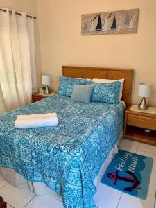 1 dormitorio con 1 cama con edredón azul en SUITE 4, Blue Pavilion - Beach, Airport Taxi, Concierge, Island Retro Chic, en West Bay