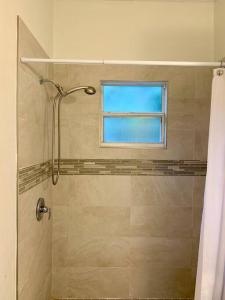 bagno con doccia e finestra di SUITE 4, Blue Pavilion - Beach, Airport Taxi, Concierge, Island Retro Chic a West Bay