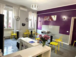 ein Restaurant mit gelben Stühlen, Tischen und lila Wänden in der Unterkunft Bed and Breakfast Le Due Civette in Rom