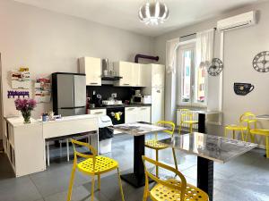 cocina con mesa de comedor y sillas amarillas en Bed and Breakfast Le Due Civette, en Roma