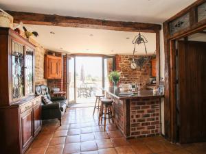 a kitchen with a counter and a brick wall at Turnip House in Plaish