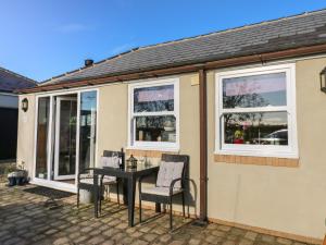 a house with a table and two chairs and windows at Grace's Retreat in Darlington