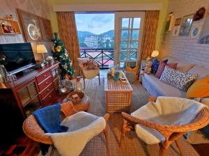 a living room filled with furniture and a christmas tree at Green Hill Tanah Rata Cameron Highland in Tanah Rata