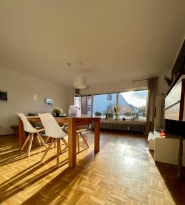 a living room with a table and chairs and a large window at pottapartments - balkon - küche - wifi - nespresso in Herne