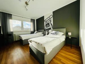 two beds in a bedroom with green walls and wood floors at pottapartments - balkon - küche - wifi - nespresso in Herne