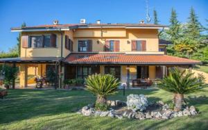 una gran casa con palmeras en el patio en Villa intera San Marco - Luxury Wine Resort en Rosignano Monferrato