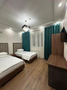a bedroom with two beds and a chandelier at Hello Dushanbe Hostel in Dushanbe