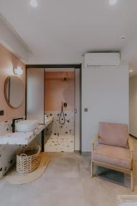 een badkamer met een stoel en een spiegel bij Fildisi luxury suites in Nafplio