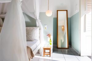 een slaapkamer met een wit bed en een spiegel bij Vila Charme in Jericoacoara