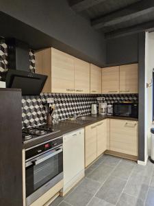 cocina con armarios de madera y horno con fogones en Le refuge de Loire, en Montrelais