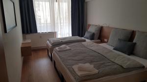 a small bedroom with two beds and a window at SKI Makov Apartmán 2L in Makov