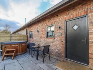 a patio with a hot tub next to a brick building at Robins Nest in York