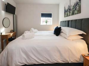 a bedroom with a large bed with white sheets and pillows at Robins Nest in York
