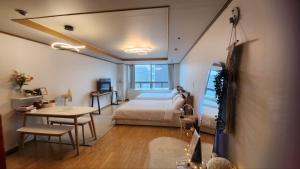 een slaapkamer met een bed, een tafel en een bureau bij Posh_HongDae in Seoul