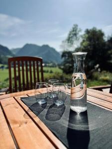 a bottle and three wine glasses sitting on a table at Ferienhaus sHäuserl in Landl +40 photos