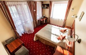 a hotel room with a bed and two windows at Galia in Druskininkai