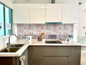 a kitchen with white cabinets and a sink at Springfield 3-Storey Cheerful Townhouse #Yoyo Homestay in Sandakan +17 photos
