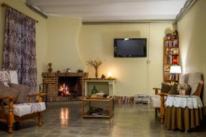 een woonkamer met een open haard en een televisie bij Hostal Montserrat in Montseny