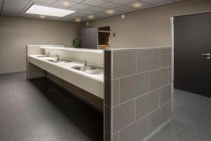- une salle de bains commune avec deux lavabos et un miroir dans l'établissement Strandcamping Jagtveld, à s-Gravenzande