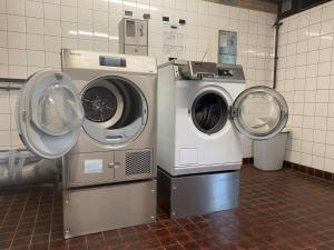 drie wasmachines naast elkaar in een ruimte bij Strandcamping Jagtveld in 's-Gravenzande