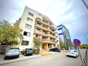ブカレストにあるBaneasa Luxury Apartamentsの前に車が駐車されている高い建物
