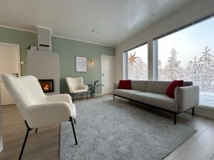 ein Wohnzimmer mit einem Sofa und 2 Stühlen in der Unterkunft Brand New! Villa Moon in Rovaniemi