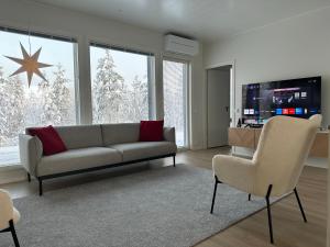 ein Wohnzimmer mit einem Sofa und 2 Stühlen in der Unterkunft Brand New! Villa Moon in Rovaniemi