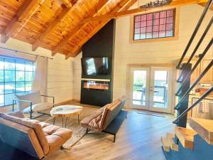 una sala de estar con un sofá y una mesa en Modern lake side nest• HOTUB Fenced YARD king beds, en Sevierville