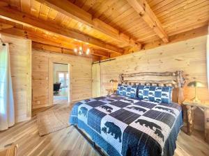 ein Schlafzimmer mit einem Bett in einem Blockhaus in der Unterkunft Modern lake side nest• HOTUB Fenced YARD king beds in Sevierville