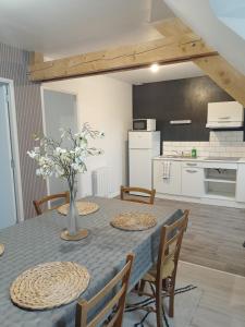 una cucina e una sala da pranzo con tavolo e sedie di appart 2 chambres a Noyen-sur-Sarthe Altre 4 foto