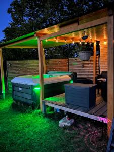 a pergola with a bed and a table with lights at Roulotte „douceur“ in Condom