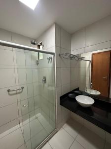 a bathroom with a glass shower and a sink at Ap. Vista pra piscina - Iloa in Barra de São Miguel