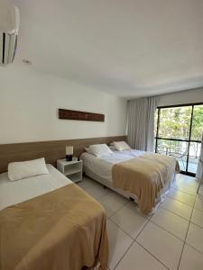 Cette chambre comprend 2 lits et une fenêtre. dans l'établissement Ap. Vista pra piscina - Iloa, à Barra de São Miguel