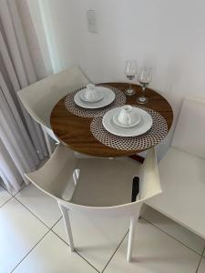 a dining room table with two glasses of wine at Ap. Vista pra piscina - Iloa in Barra de São Miguel