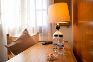 a bottle of water sitting on a table with a lamp at Hostal Montserrat in Montseny