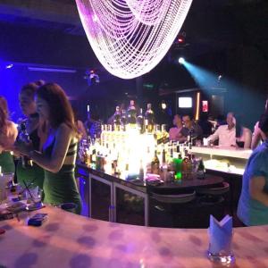 a group of people in a bar with a bartender at Moon's Home in Ho Chi Minh City