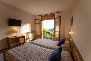 a bedroom with a bed and a large window at Hostal Montserrat in Montseny