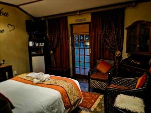 a bedroom with a bed and a chair and a window at A Cherry Lane Self Catering and B&B in Bloemfontein