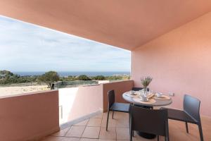 a dining room with a table and chairs on a balcony at Residence Rocce Rosse in Isola Rossa
